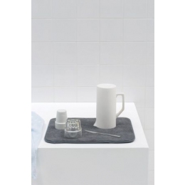 Brabantia absorbējošs virtuves paklājiņš trauku žāvēšanai demonstrē ūdens uzsūkšanas spējas